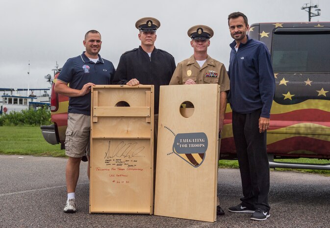 Members of Tailgate for Troops donate corn hole gear to Chief Petty Officer Jeremy Price, a machinist mate assigned to the Naval Consolidated Brig Charleston, and Chief Petty Officer Brad Carman, a gunner’s mate assigned to NCBC, Sept. 26, 2014, at Patriots Point in Mount Pleasant, S.C. Tailgate for Troops held a corn hole tournament aboard the U.S.S. Yorktown in downtown Charleston and invited members from all services to participate in the free event. (U.S. Air Force photo/Senior Airman George Goslin)