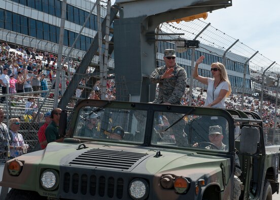 Col. Michael Grismer, 436th Airlift Wing commander, and his wife Dr. Linda Grismer, wave to the crowd at the during the pre-race at 2014 AAA 400, NASCAR Sprint Cup Series, Sept. 28, 2014, at the Dover International Speedway in Dover, Del. The Grismers took part in a pre-race parade. (U.S. Air Force photo/Airman 1st Class Zachary Cacicia) 