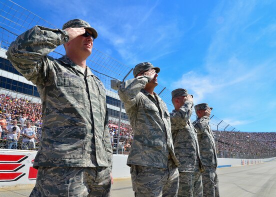Col. Michael Grismer, 436th Airlift Wing commander, and other senior leadership from Team Dover salute during the singing of the national anthem before the start of the 2014 AAA 400, NASCAR Sprint Cup Series race Sept. 28, 2014, at the Dover International Speedway in Dover, Del. The Dover Air Force Base Honor Guard rendered the colors during the national anthem. (U.S. Air Force photo/Airman 1st Class William Johnson)