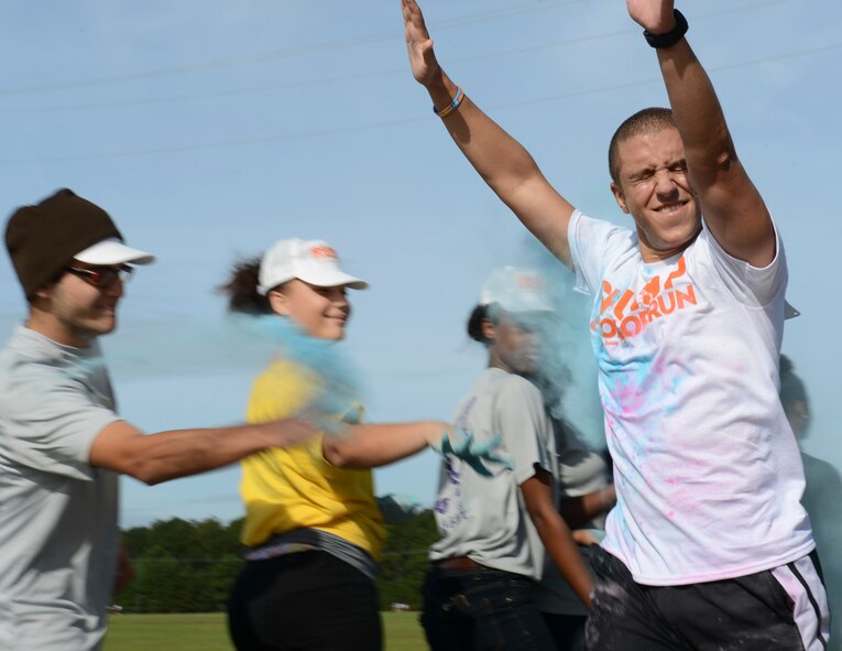 A Shut Up and Color Run 5K participant is covered in blue powder as he passes by a color station at Shaw Air Force Base, S.C., Sept. 27, 2014. Volunteers at the run used a cornstarch powder, making it environmentally safe and approved by the 20th Fighter Wing safety office. (U.S. Air Force photo by Senior Airman Tabatha Zarrella/Released) 
