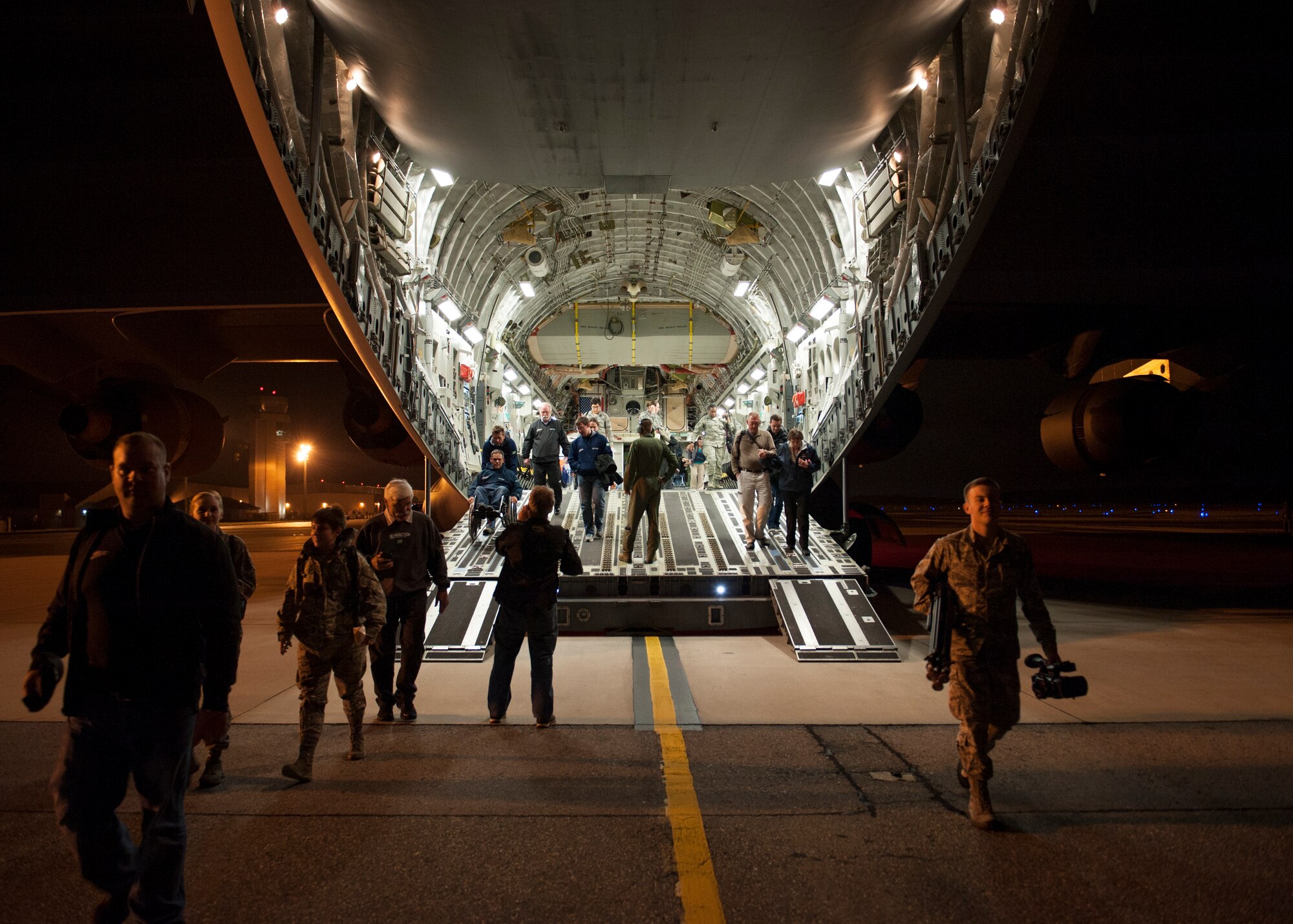 Team Dover Airmen and members from Germain Racing, Chip Ganassi Racing and NASCAR exit via the rear ramp of a C-17 Globemaster III cargo plane after a community relations orientation flight Sept. 25, 2014, at Dover Air Force Base, Del. The flight saw 14 aerial refueling closures, an assault landing and a combat offload. (U.S. Air Force photo/Airman 1st Class Zachary Cacicia)  