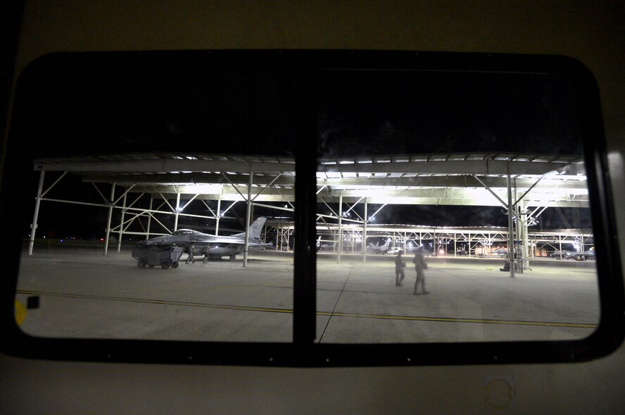 U.S. Air Force crew chiefs are seen performing maintenance on F-16CM Fighting Falcons from the window of an expeditor truck on the flightline at Shaw Air Force Base, S.C., Sept. 18, 2014. Crew chiefs are often transported from aircraft to aircraft via expeditor trucks in order for them to perform maintenance on the planes, keeping them mission ready. (U.S. Air Force photo by Staff Sgt. Kenny Holston/Released) 