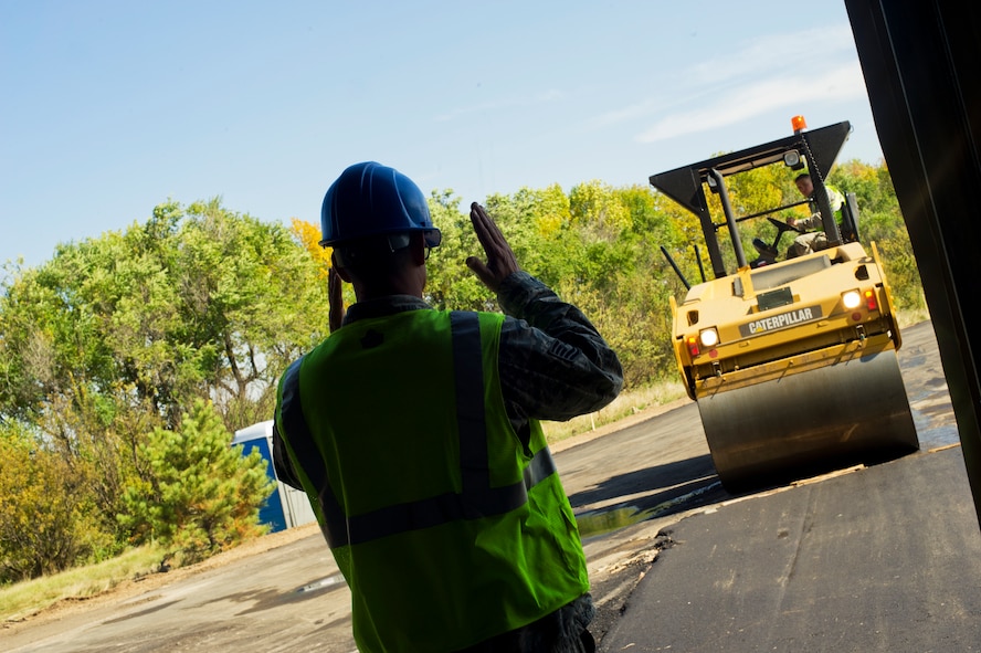 Airmen from the 5th Civil Engineer Squadron pave cement during the construction of the new search facility on Minot Air Force Base, N.D., Sept. 19, 2014. To help shield Airmen from harsh weather conditions, members of the 5th CES are building the search facility for the 5th Security Forces Squadron defenders. (U.S. Air Force photo/Senior Airman Brittany Y. Bateman)