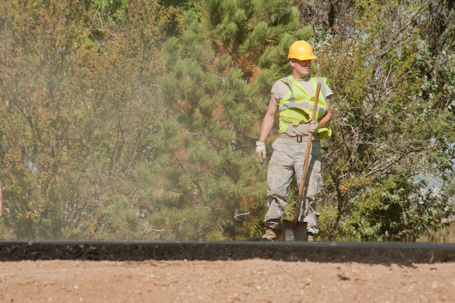 An Airman from the 5th Civil Engineer Squadron shovels dirt during the construction of the new search facility on Minot Air Force Base, N.D., Sept. 19, 2014. In addition to sheltering defenders from harsh weather, the facility also increases commercial vehicle search capabilities with a more robust and secure search facility. (U.S. Air Force photo/Senior Airman Brittany Y. Bateman)