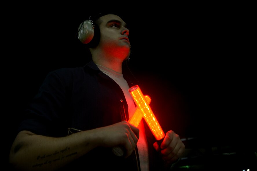U.S. Air Force Senior Airman Perry Clark, 20th Aircraft Maintenance Squadron dedicated crew chief, prepares to marshal an F-16CM Fighting Falcon during night operations at Shaw Air Force Base, S.C., Sept. 18, 2014. Crew chiefs are responsible for keeping the multi-million dollar fighting falcon mechanically sound and combat ready. (U.S. Air Force photo by Staff Sgt. Kenny Holston/Released)