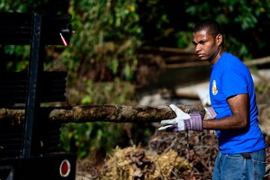 U.S. Air Force Airman 1st Class Walter Johnson, 633rd Force Support Squadron volunteer, clears debris as part of a restoration project at Bethel Park and Family Campground in Hampton, Va., Sept. 27, 2014. The restoration project included removing an unclaimed old tire stockpile, creating a Bayscape pollinator garden, riparian buffer, native tree planting, installing wildlife nesting boxes and constructing a floating dock for wildlife observation and fishing. (U.S. Air Force photo by Senior Airman Kayla Newman/Released) 
