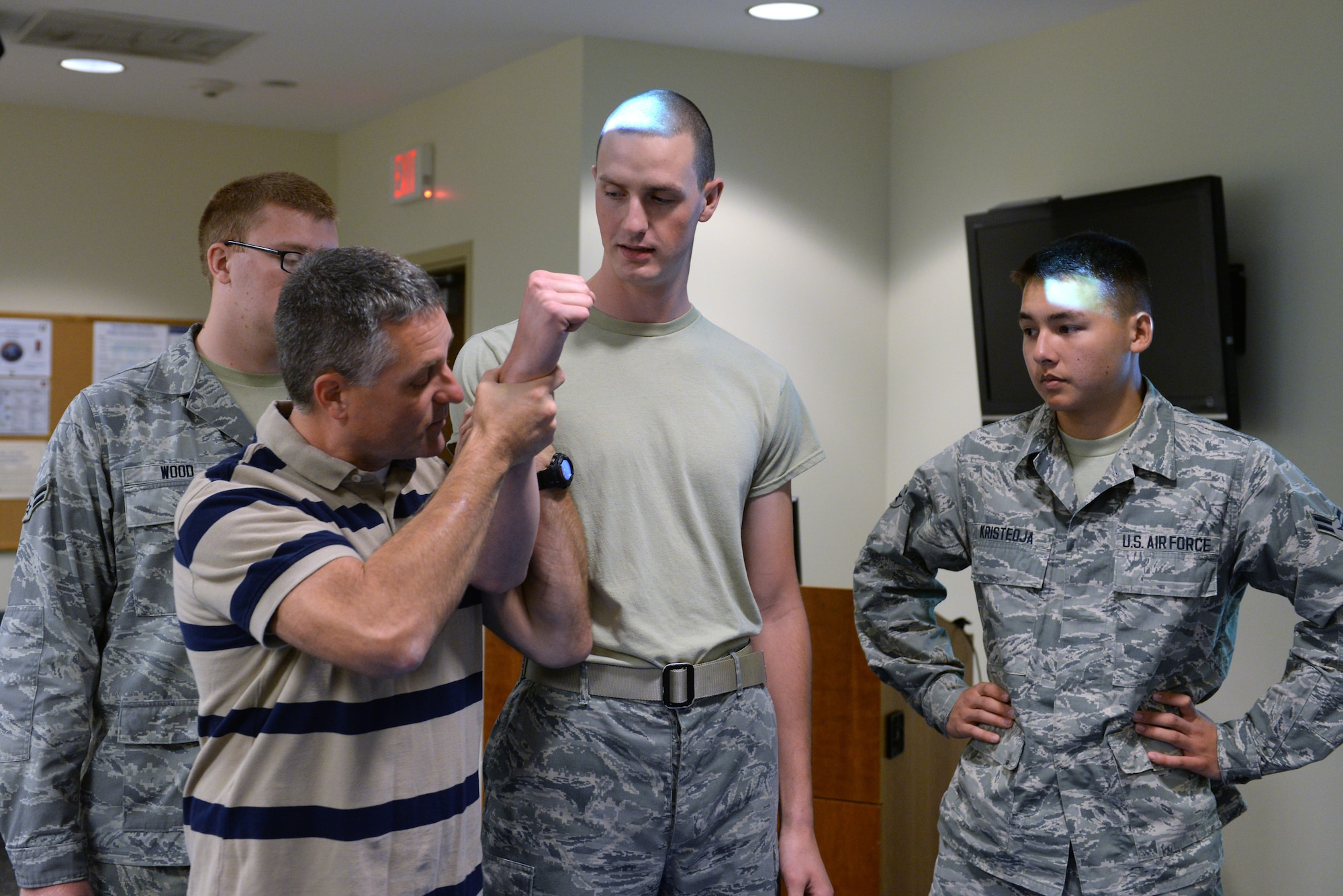 Joe Holtz, 375th Security Forces Squadron trainer, demonstrates how to properly hold an individual while they are tased Sept. 25, 2014 at Scott Air Force Base, Ill. Holtz was teaching SF augmentees the effects of being tased such as muscles locking up and lack of body control. (U.S. Air Force photo/Staff Sgt. Jonathan Fowler)
