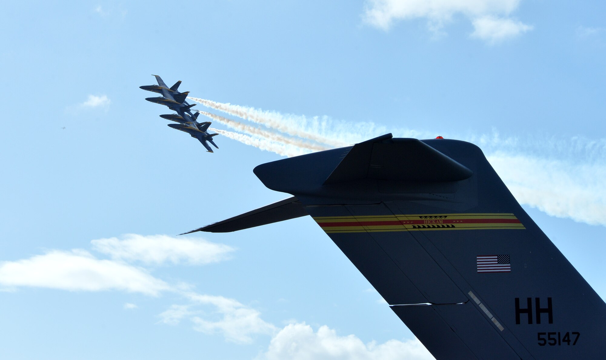 Navy Blue Angels fly in formation near a C-17 Globemaster III from the 535th Airlift Squadron during the Wings Over the Pacific Air Show at Joint Base Pearl Harbor-Hickam, Hawaii, Sept. 27, 2014. The Blue Angels wowed spectators twice during the two-day show. Other aerial demonstrations included the F-22 Raptor Aerial Demonstration Team and the Navy Leap Frogs Parachute Team. (U.S. Air Force photo by Staff Sgt. Alexander Martinez/Released)  