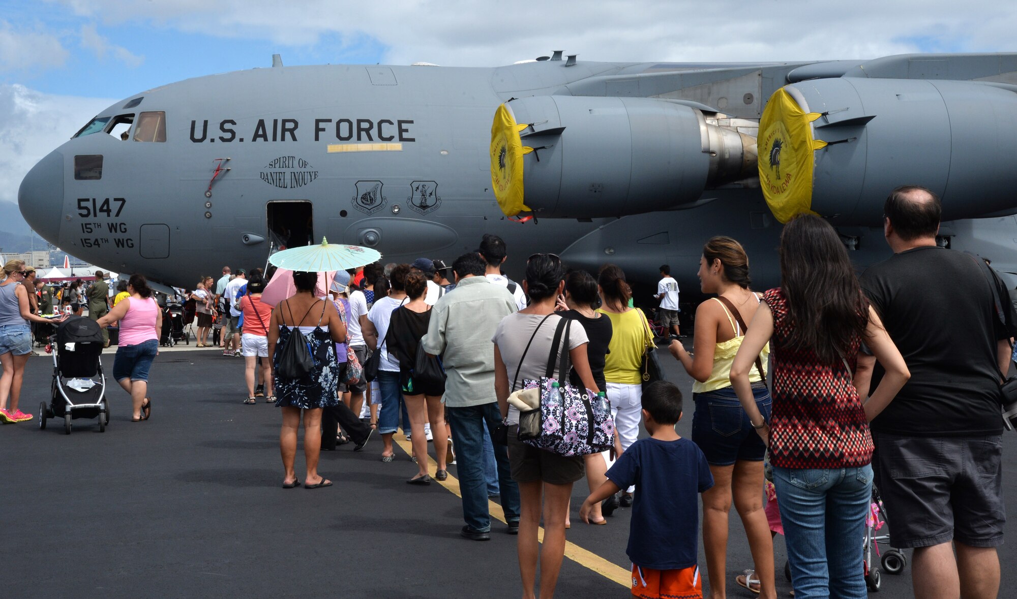 Attendees of the Wings Over the Pacific Air Show wait in line to board a C-17 Globemaster III at Joint Base Pearl Harbor-Hickam, Hawaii, Sept. 27, 2014. Inside the aircraft, air crew members were present to answer any questions. Thousands of spectators witnessed aerial performances by demonstration teams including the F-22 Raptor Aerial Demonstration Team and the Navy Blue Angels. (U.S. Air Force photo by Staff Sgt. Alexander Martinez/Released)   