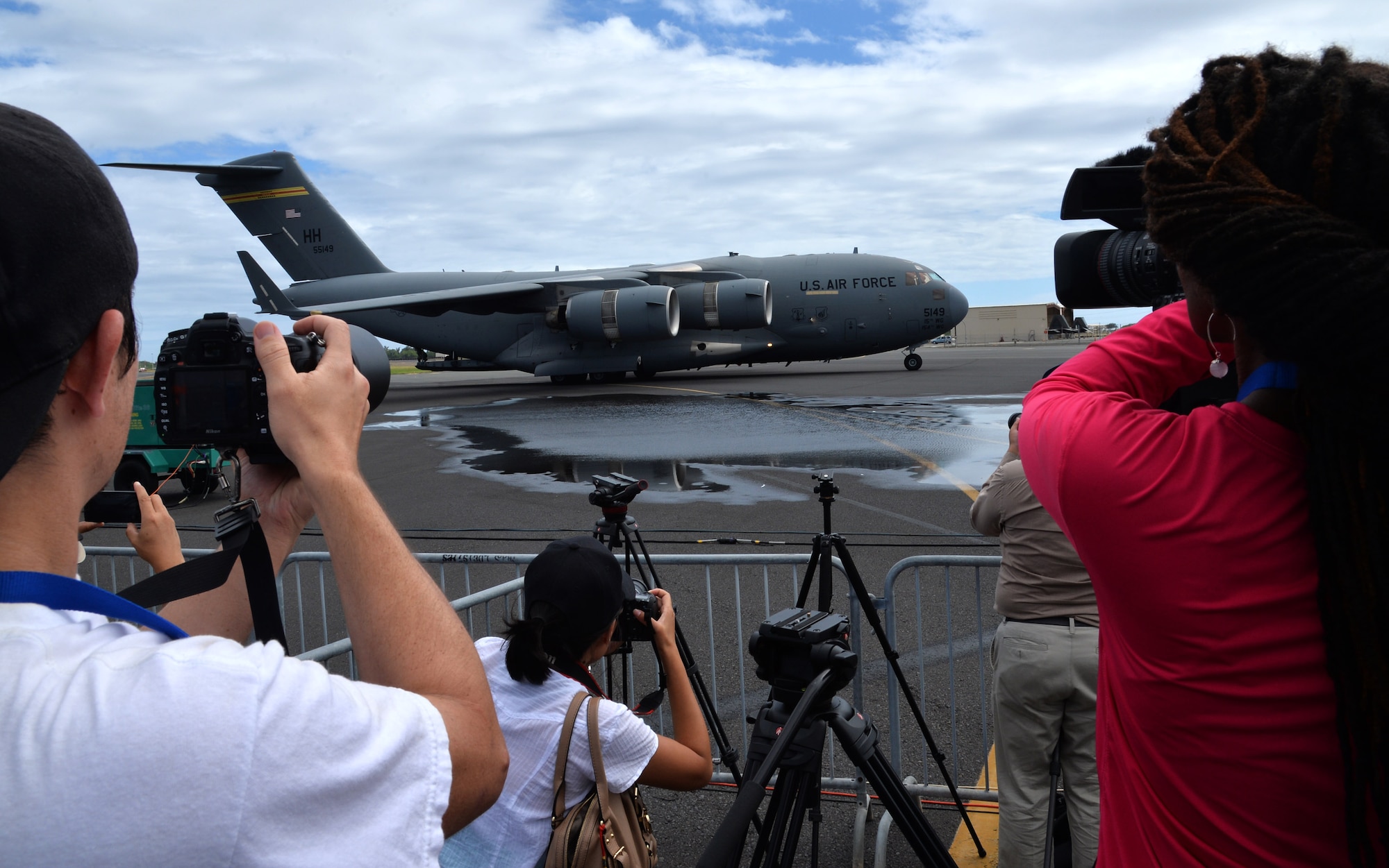 Members of the media capture images and video of a C-17 Globemaster III following its flight run during the Wings Over the Pacific Air Show at Joint Base Pearl Harbor-Hickam, Hawaii, Sept. 27, 2014. Thousands of spectators witnessed aerial performances by demonstration teams including the F-22 Raptor Aerial Demonstration Team and the Navy Blue Angels. Static displays of aircraft and equipment from the Air Force, Navy, Marines and Army gave attendees the opportunity to interact with the equipment and operators. (U.S. Air Force photo by Staff Sgt. Alexander Martinez/Released)  