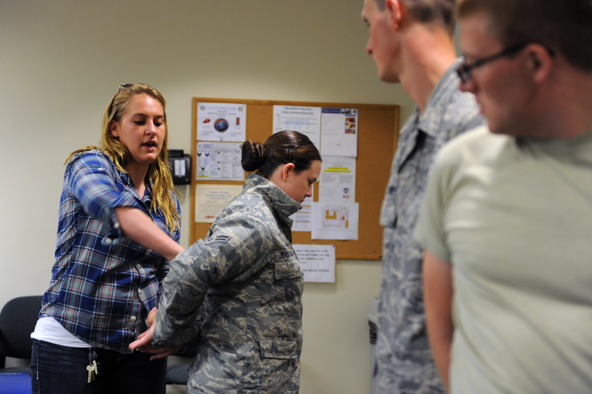 Airman 1st Class Yvette Tedmon, 375th Security Forces Squadron, instructs augmentees on how to properly search a suspect Sept. 24, 2014 at Scott Air Force Base, Ill. Augmentees learned how to safely conduct a full body search in addition to proper procedures for hand cuffing and handling a suspect. (U.S. Air Force photo/Staff Sgt. Jonathan Fowler)