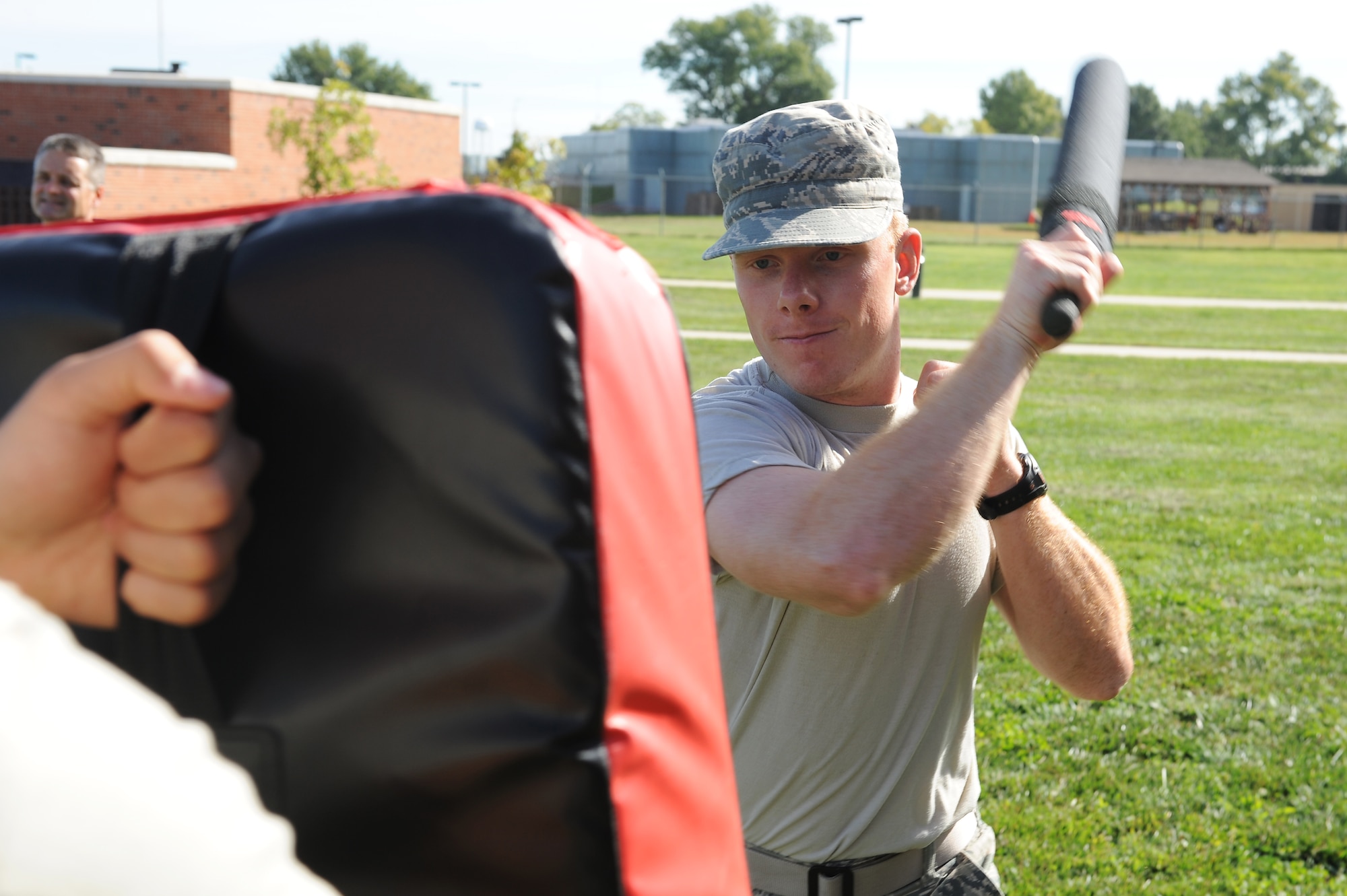 Airman 1st Class James Lobban, 375th Medical Support Squadron, swings at a pad during a 375th Security Forces Squadron augmentee training session Sept. 24, 2014 at Scott Air Force, Ill. Security Forces augmentees were trained in basic self defense and non lethal tactics as well as proper procedures for apprehending a suspect, calling in specific radio codes and other basic police procedures. (U.S. Air Force photo/Staff Sgt. Jonathan Fowler)