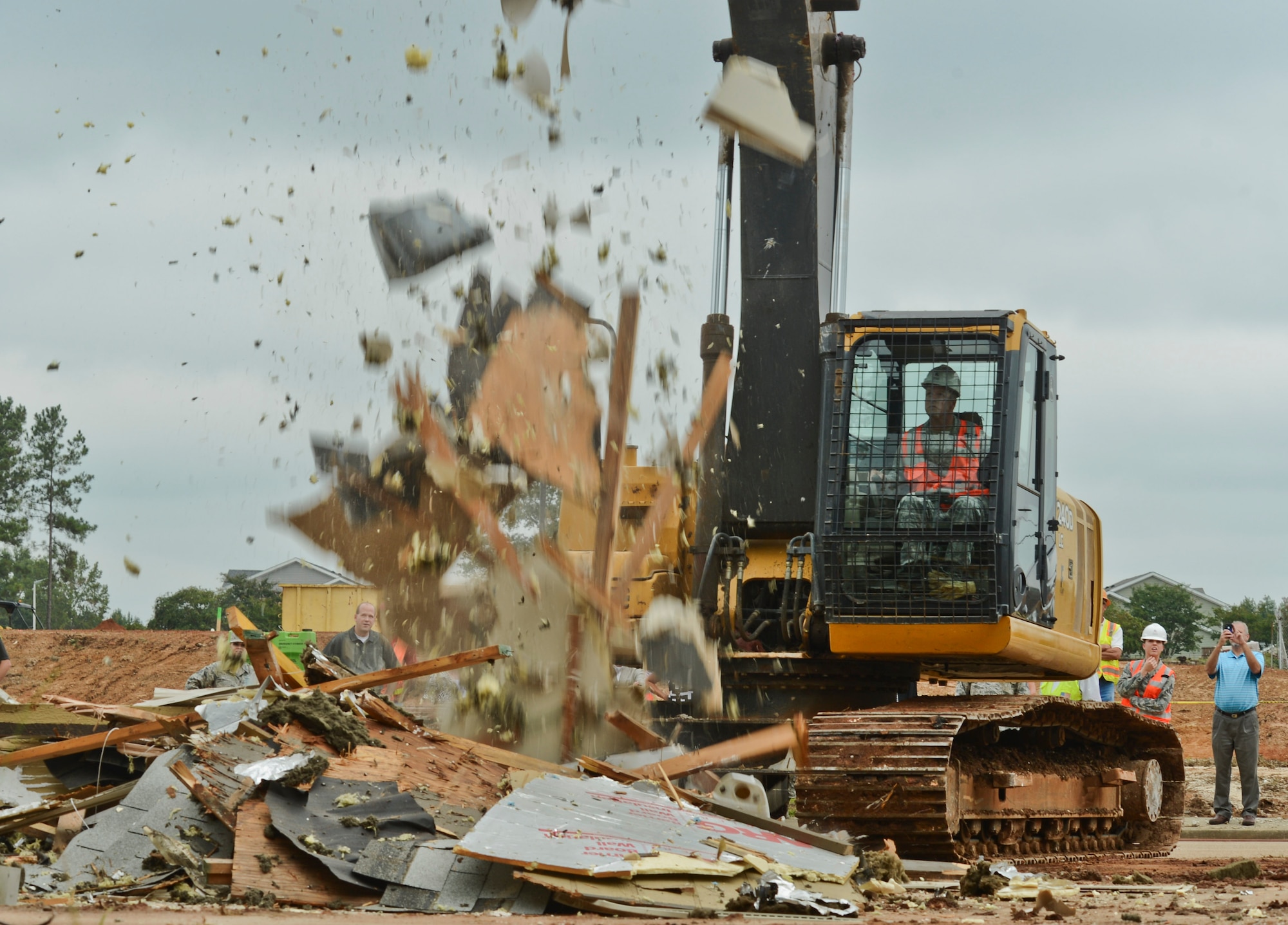 U.S. Air Force Col. William Jones, 20th Fighter Wing vice commander, drops debris during the junior NCO base housing demolition at Shaw Air Force Base, S.C., Sept. 15, 2014. The importance of the demolition was to signify the completion of the three-year demolition.  Clearing acreage for new housing construction. (U.S. Air Force photo by Senior Airman Tabatha Zarrella/Released)