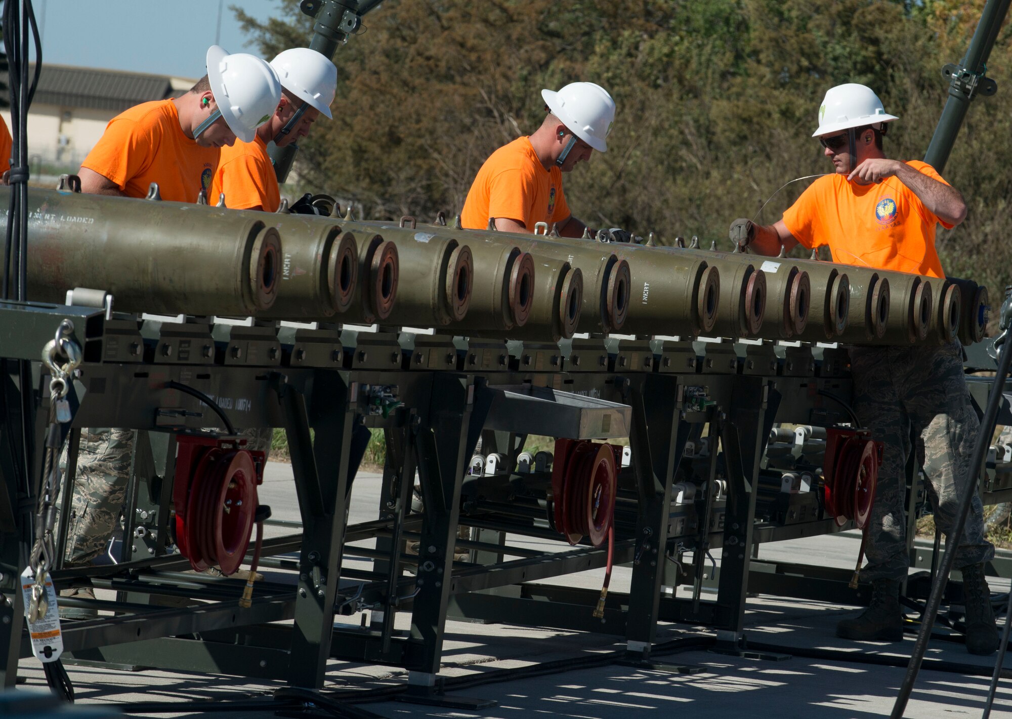 Members of the 5th Munitions Squadron lower a weapon onto a munitions assembly conveyor on Minot Air Force Base, N.D., Sept. 23, 2014. The 5th MUNS portion of the 2014 Global Strike Challenge consisted of building and loading munitions in a race against the clock. (U.S. Air Force photo/Airman 1st Class Sahara L. Fales)