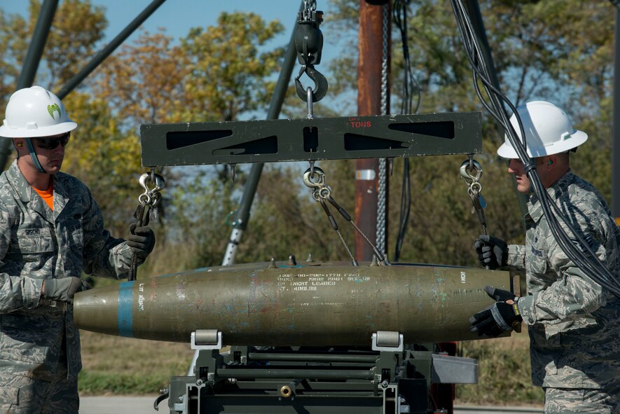 Members of the 5th Munitions Squadron lower a weapon onto a munitions assembly conveyor on Minot Air Force Base, N.D., Sept. 23, 2014. The 5th MUNS portion of the 2014 Global Strike Challenge consisted of building and loading munitions in a race against the clock. (U.S. Air Force photo/Airman 1st Class Sahara L. Fales)