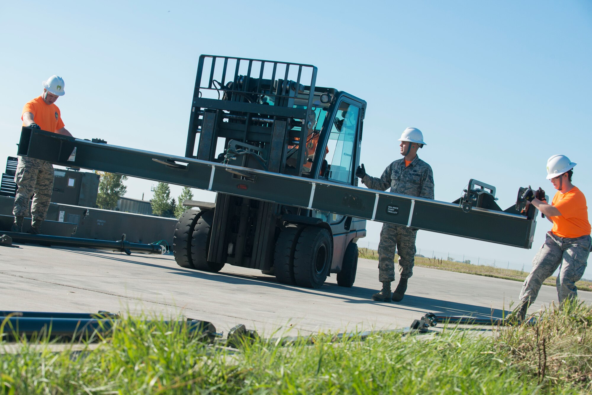 Members of the 5th Munitions Squadron guide a forklift on Minot Air Force Base, N.D., Sept. 23, 2014. The team constructed a munitions assembly conveyor to place munitions on during assembly and disassembly as a part of the 2014 Global Strike Challenge. (U.S. Air Force photo/Airman 1st Class Sahara L. Fales)