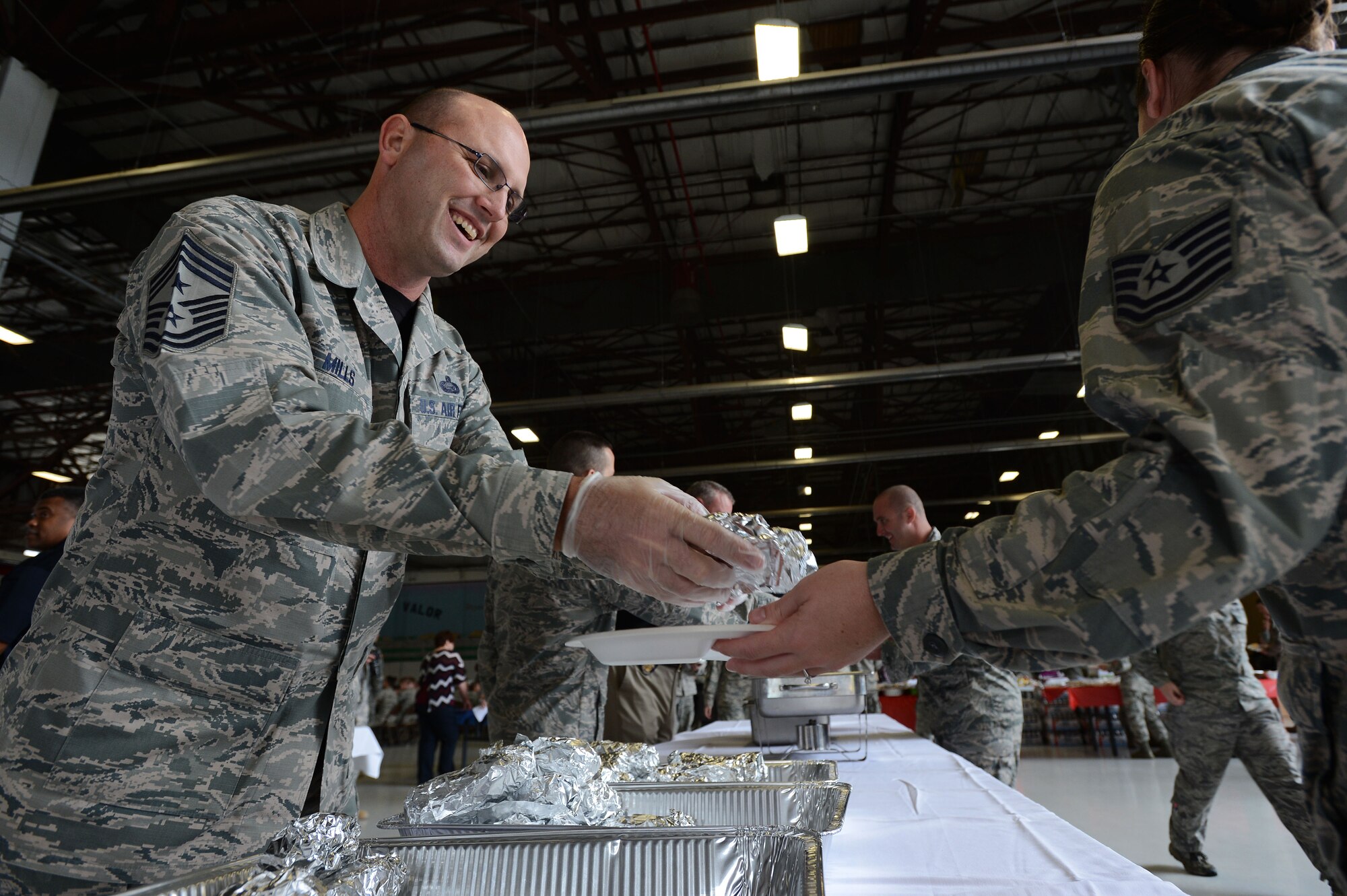 Chief Master Sgt. Charles Mills, 20th Fighter Wing command chief, serves lunch during the 6th Annual Military Appreciation Picnic at Shaw Air Force Base, S.C., Sept. 26, 2014. Several Team Shaw leaders served the hundreds of Airmen and soldiers who attended the picnic. (U.S. Air Force photo by Airman 1st Class Jensen Stidham/Released)