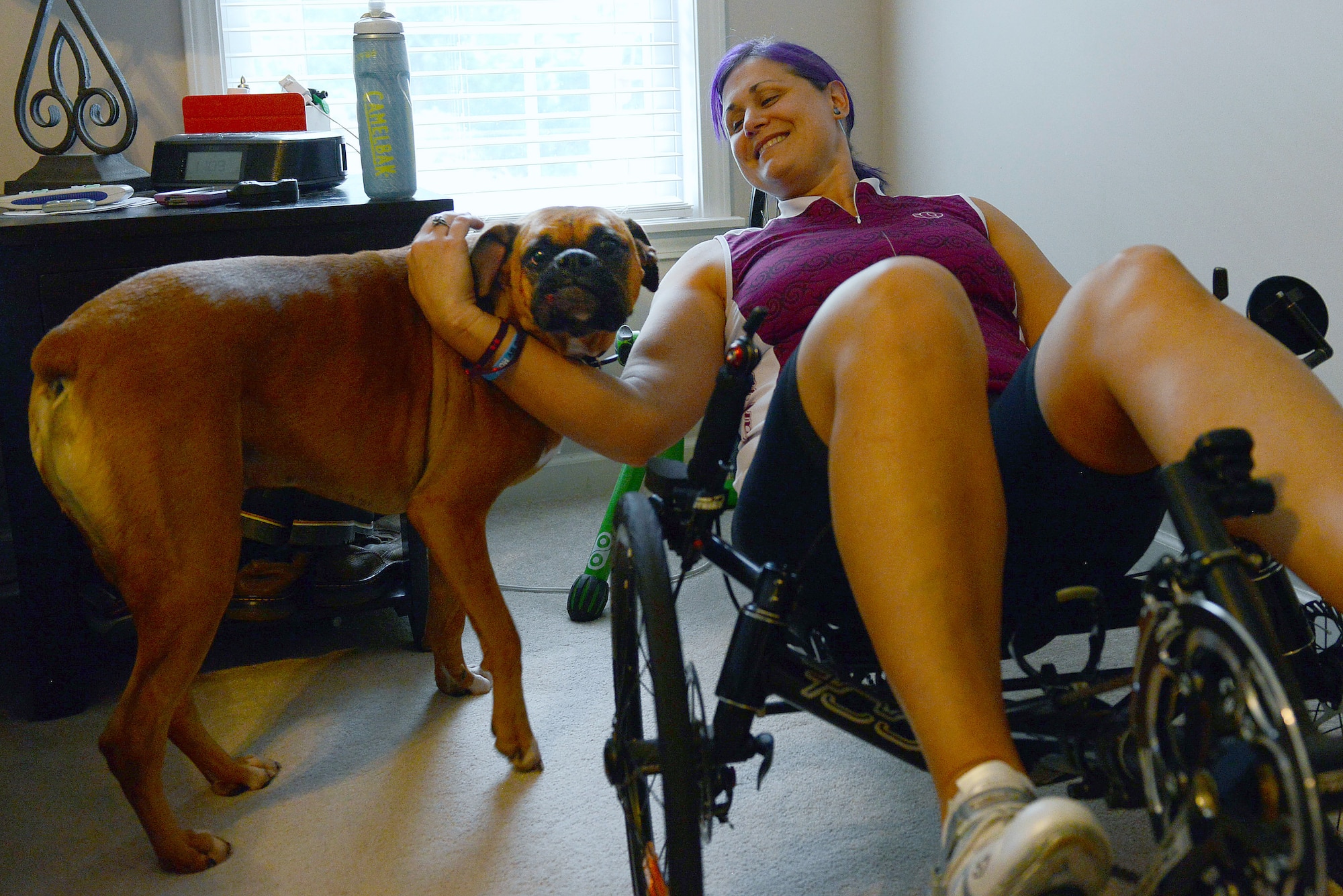 Retired U.S. Air Force Maj. Jen Kyseth, trains on her recumbent bike while her dog Mack waits by her side, Sumter, S.C., Sept. 15, 2014. Every time Kyseth trains on her bike, Mack is there with her as if he’s trying to show support which boosts her motivation. (U.S. Air Force photo by Airman 1st Class Diana M. Cossaboom/Released)