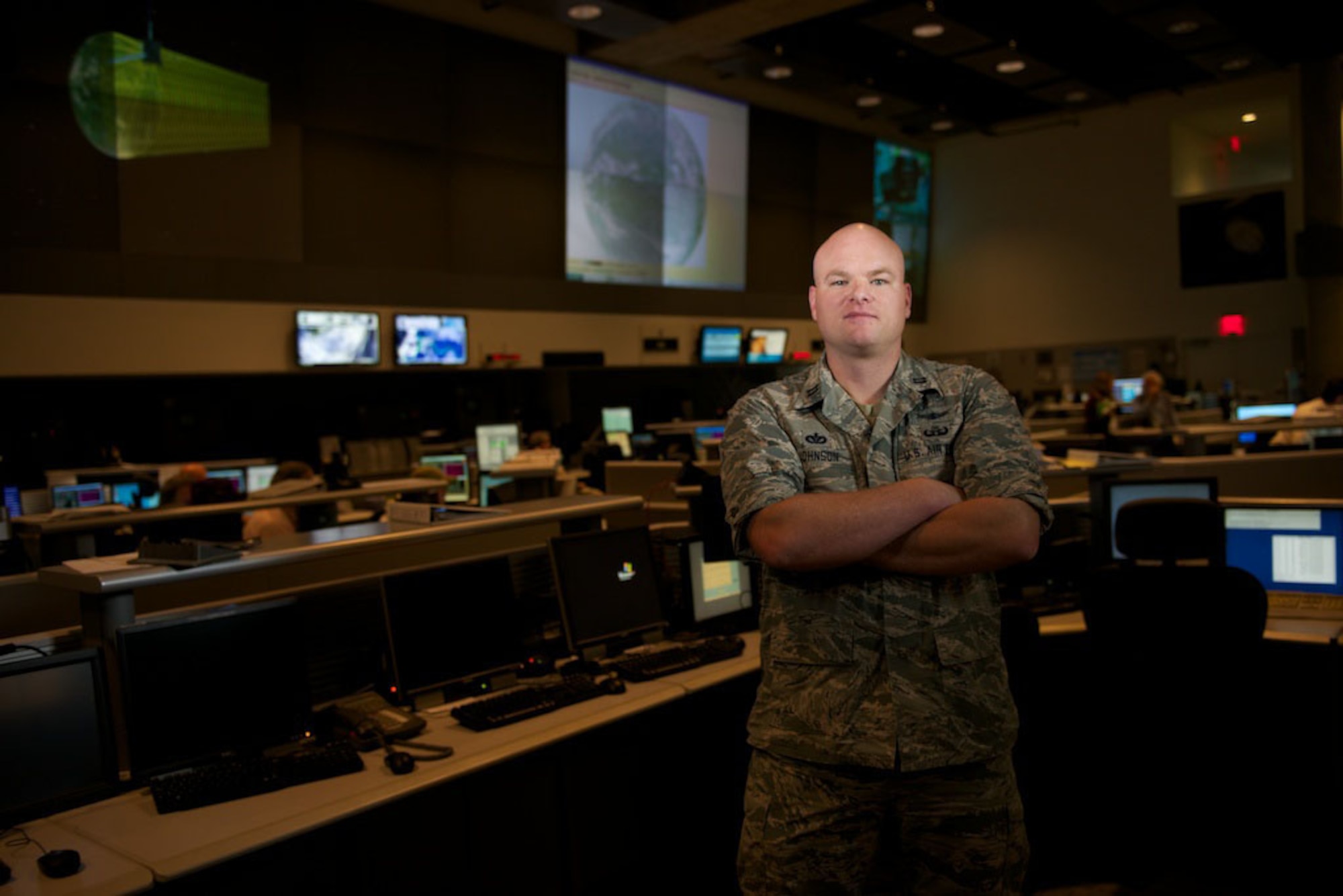 Capt. Tyson Johnson stands in the satellite operations center Sept. 25, 2014, at the National Oceanic and Atmospheric Administration’s satellite operations facility in Suitland, Md. Johnson is the ground flight commander with Detachment 1, 50th Space Operations Group. The geographically separated unit manages the Defense Meteorological Satellite Program – the only weather satellite system in the DOD – in cooperation with NOAA engineers and satellite operators. The system supplies weather data to the Air Force Weather agency as well as military and civilian organizations around the world. (U.S. Air Force photo/Senior Airman Alexander W. Riedel)