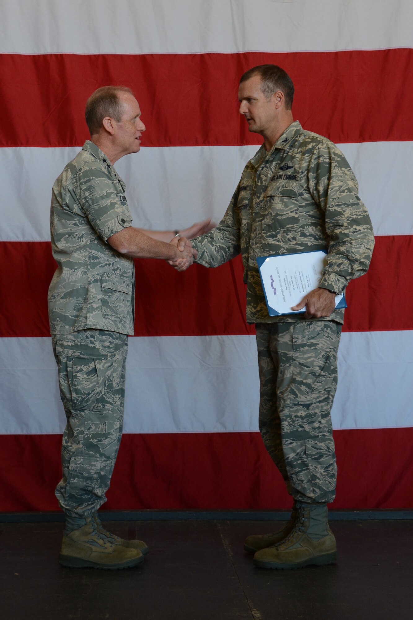 Col. Jeffrey Wiegand, 115th Fighter Wing commander, shakes hands with Maj. Gen. Donald P. Dunbar, adjutant general for Wisconsin, following the acceptance of the 2013 Air Force Outstanding Unit Award certificate during Wingman Day in Hangar 406 in Madison, Wis., Sept. 7, 2014. This is the eighth time the unit has won the award. (Air National Guard photo by Senior Airman Andrea F. Rhode)