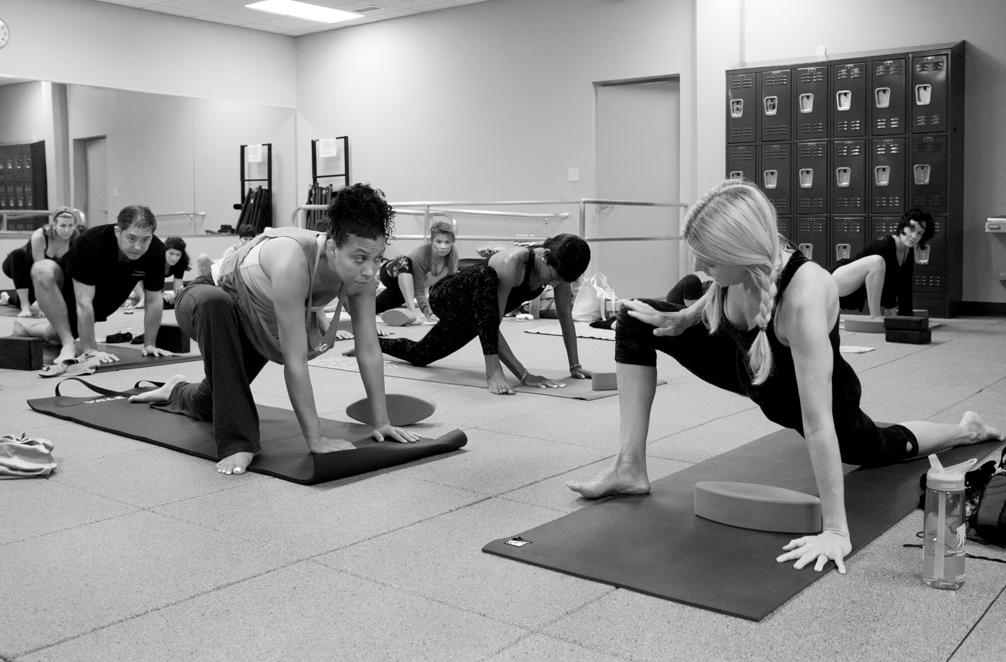 Yoga class participants move into a variation of the kneeling lunge pose led by YogaFit Master Instructor, Shaye Molendyke Sept. 27 at Eglin’s women’s field house.  The 96th Force Support Squadron hosted the 20-hour yoga workshop designed to assist participants in gaining a deeper understanding of how trauma is stored in the body.  This yoga program is different than traditional yoga practice in that it targets the healing of the central nervous system.  This program’s classes focus on slower organic yoga postures and movements while creating a safe space for the trauma survivor to heal.  (U.S. Air Force photo/Ilka Cole)