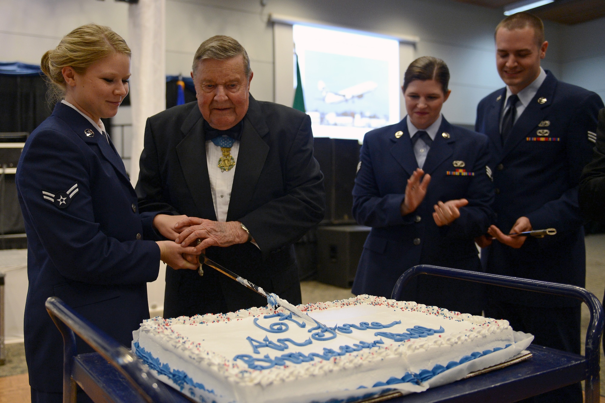 Airman 1st Class Taylor Walker (left), 627th Air Base Group executive assistant, and retired Col. Joe Jackson, Medal of Honor recipient, cut a cake with a saber Sept. 26, 2014, during the Air Force Ball at Clover Park Technical College, Lakewood, Wash. After the cake cutting, Walker, the most junior Air Force member at the ball, was presented with the gift of a saber to remind her that the Air Force is a profession of arms. (U.S. Air Force photo/Airman 1st Class Keoni Chavarria)