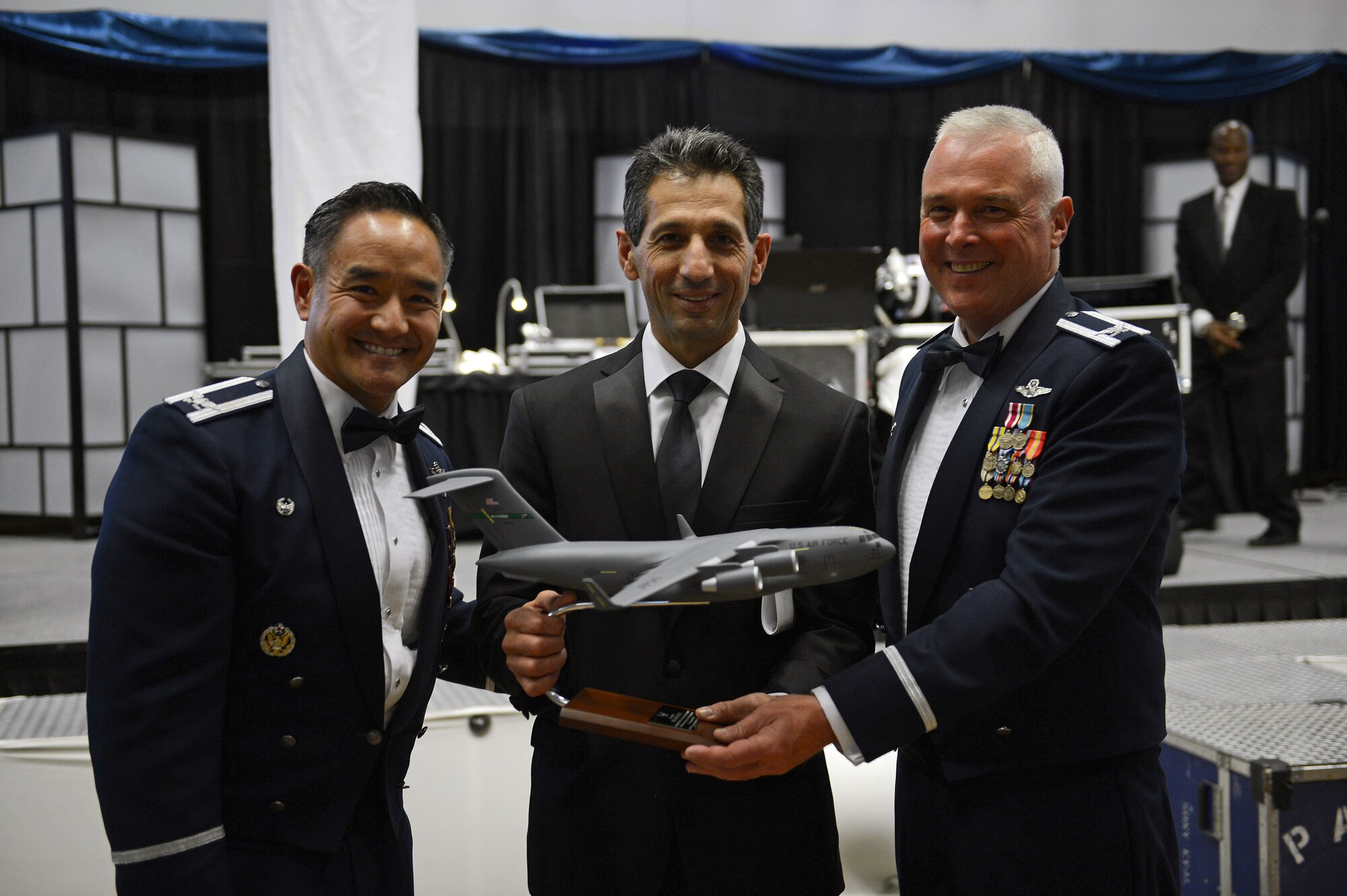 Col. David Kumashiro (left), 62nd Airlift Wing commander, and Col. Scott McLaughlin (right), 446th Airlift Wing commander, present Ben Minicucci, Alaska Airlines chief operating officer and executive vice president, with a gift of a model C-17 Sept. 26, 2014, during the Air Force Ball at Clover Park Technical College, Lakewood, Wash. Minicucci, a 14-year veteran of the Canadian Armed Forces, gave a presentation on leader ship and advice on how to build a stronger foundation. (U.S. Air Force photo/Airman 1st Class Keoni Chavarria)