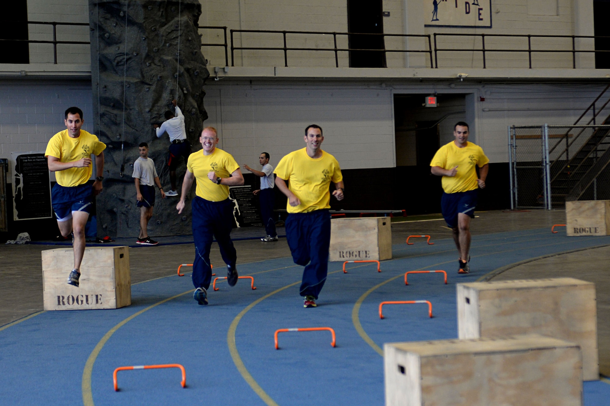 Airmen from the 37th Bomb Squadron participate in an obstacle course during a Comprehensive Airman Fitness day in the Pride Hangar at Ellsworth Air Force Base, S.D., Sept. 30, 2014. Teams of four Airmen participated in the course which consisted of 12 different events, including a sandbag carry, low crawls and a rock-wall climb. (U.S. Air Force photo by Airman 1st Class Rebecca Imwalle/Released)