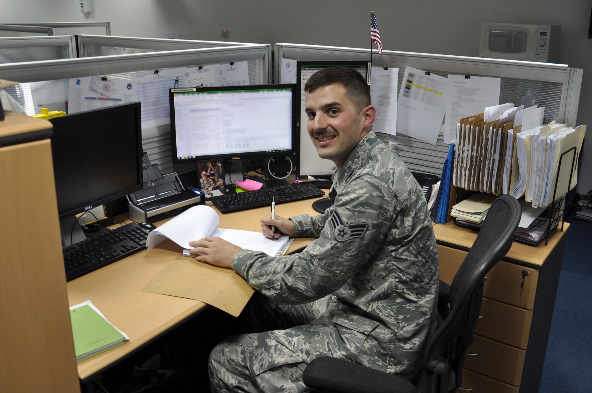 Senior Airman Garrett Murray, 380th Expeditionary Contracting Squadron contracting officer, works at his desk while deployed to Southwest Asia, Sept. 25, 2014. Murray is deployed from the 319th Contracting Flight on Grand Forks Air Force Base, N.D., and currently works small supply purchases. (Courtesy photo)