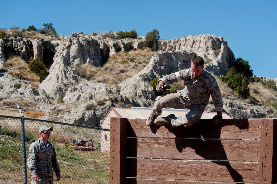 Senior Airman Patrick Wagenecht, 91st Security Forces Group Global Strike Challenge team member, jumps over an obstacle during the mental and physical challenge on Camp Guernsey Wyo., Sept. 25, 2014. The security forces portion of the challenge was split into three different events; tactics, weapons firing, and the mental and physical challenge. (U.S. Air Force photo/Senior Airman Brittany Y. Bateman)