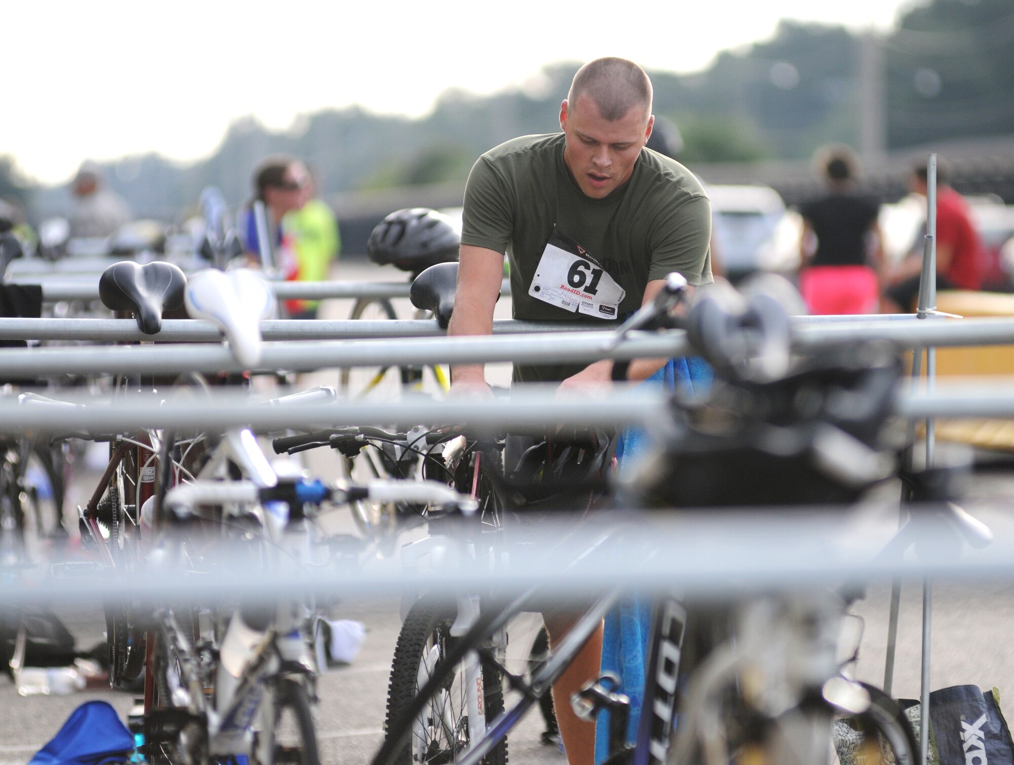 Staff Sgt. Robert Hendrickson, 338th Training Squadron, secures his bike to the rack as he transitions from cycling to running during Keesler's mini-triathlon Sept. 26, 2014, at Keesler Air Force Base, Miss.  The event consists of a 9-mile bike ride, a 2-mile run and a 200-yard swim.  (U.S. Air Force photo by Kemberly Groue)