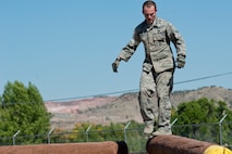 Capt. Kyle Yates, 91st Security Forces Group Global Strike Challenge team leader, walks across an obstacle during the mental and physical challenge on Camp Guernsey Wyo., Sept. 25, 2014. The security forces portion of the challenge was split into three different events; tactics, weapons-firing, and the mental and physical challenge.  (U.S. Air Force photo/Senior Airman Brittany Y. Bateman)