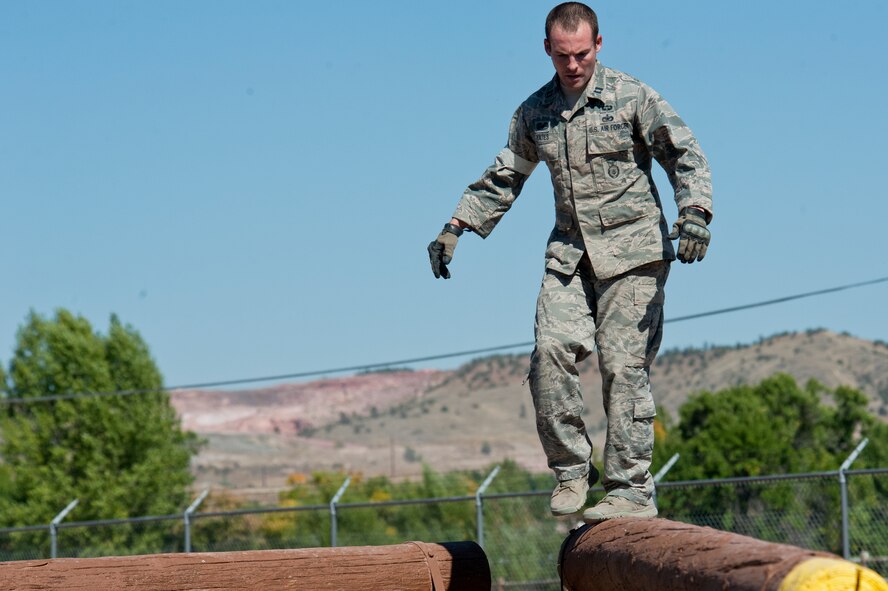 Capt. Kyle Yates, 91st Security Forces Group Global Strike Challenge team leader, walks across an obstacle during the mental and physical challenge on Camp Guernsey Wyo., Sept. 25, 2014. The security forces portion of the challenge was split into three different events; tactics, weapons-firing, and the mental and physical challenge.  (U.S. Air Force photo/Senior Airman Brittany Y. Bateman)