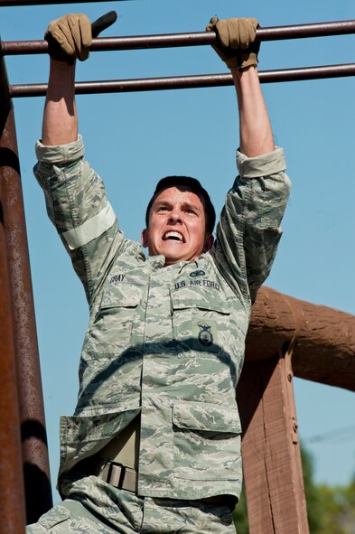 Airman 1st Class Marty Gray, 91st Security Forces Group Global Strike Challenge team member, climbs the monkey bars during the mental and physical challenge on Camp Guernsey Wyo., Sept. 25, 2014. During the challenge, the team also competed in weapons firing and a tactics event.  (U.S. Air Force photo/Senior Airman Brittany Y. Bateman)
