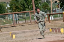 Airman 1st Class Marty Gray, 91st Security Forces Group Global Strike Challenge team member, runs to the next obstacle during the mental and physical challenge on Camp Guernsey Wyo., Sept. 25, 2014.  During the challenge, the team also competed in weapons firing and a tactics event. (U.S. Air Force photo/Senior Airman Brittany Y. Bateman)