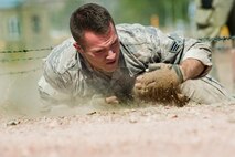 Senior Airman Patrick Wagenecht, 91st Security Forces Group Global Strike Challenge team member, low crawls through an obstacle during the mental and physical challenge on Camp Guernsey Wyo., Sept. 25, 2014. Nine teams competed in the security forces portion of the challenge. (U.S. Air Force photo/Senior Airman Brittany Y. Bateman)