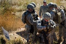 Members of the 91st Security Forces Group Global Strike Challenge team prepare their gear and receive a briefing before moving on to the next firing range during the weapons firing event at the 2014 GSC on Camp Guernsey, Wyo., Sept. 24, 2014. During the weapons firing event, the team fired the M9 pistol, M240 machine gun, M4 rifle and the M203 grenade launcher.  (U.S. Air Force photo/Senior Airman Brittany Y. Bateman)