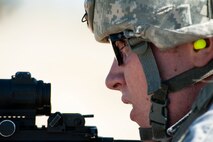 Airman 1st Class Marty Gray, 91st Security Forces Group Global Strike Challenge team member, looks down range before firing his M4 rifle during the weapons-firing event at the 2014 GSC on Camp Guernsey, Wyo., Sept. 24, 2014. Nine teams competed in the security forces portion of the challenge. (U.S. Air Force photo/Senior Airman Brittany Y. Bateman)