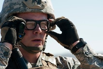 Staff Sgt. Ryan Fontaine, 91st Security Forces Group Global Strike Challenge team coach, looks down range during the weapons firing event at the 2014 GSC on Camp Guernsey, Wyo., Sept. 24, 2014. Nine teams competed in the security forces portion of the challenge. (U.S. Air Force photo/Senior Airman Brittany Y. Bateman)