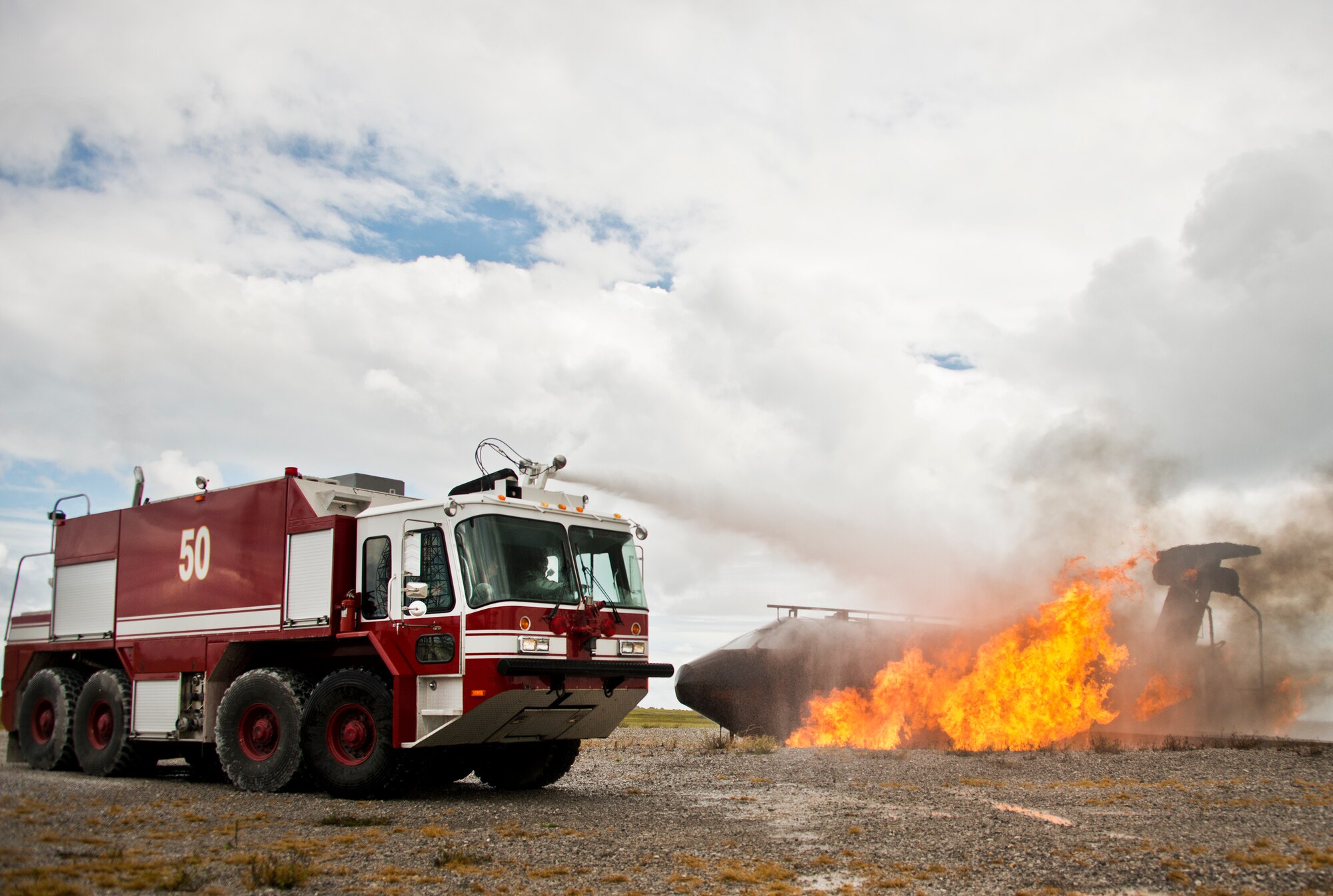 Brig. Gen. David Harris, 96th Test Wing commander, attacks the aircraft fire from Fire Truck 51 Sept. 29 at Eglin Air Force Base, Fla.  Harris visited the 96th TW flightline fire department and participated in hands-on firefighter training including live fire, structural and confined spaces.  (U.S. Air Force photo/Samuel King Jr.)