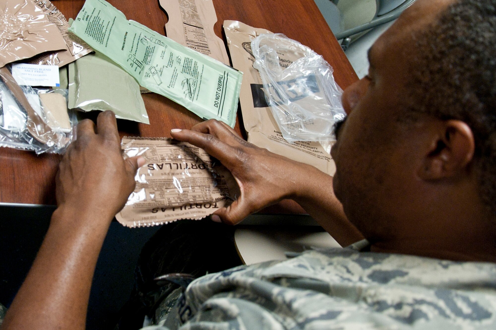 Airman 1st Class Vincent Jones, a pest management journeyman assigned to the 307th Civil Engineer Squadron prepares an MRE (Meals Ready to Eat) for lunch during a training exercise at Barksdale Air Force Base, La., Sept. 10, 2014. Jones was participating in a bivouac designed to complete yearly requirements in field and contingency skills training. (U.S. Air Force photo by Master Sgt. Jeff Walston/Released)