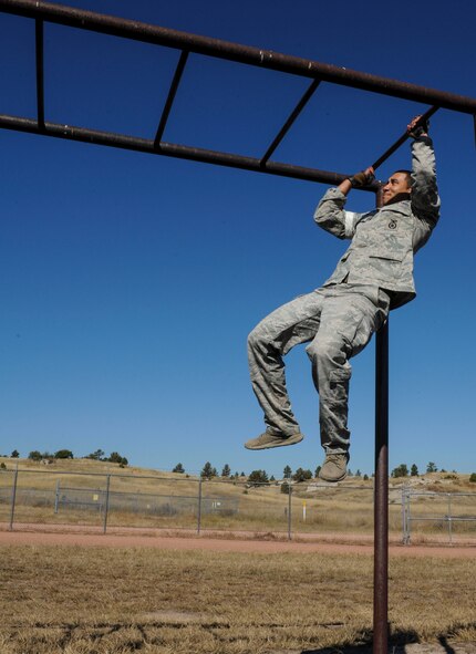 Staff Sgt. Rodrique Welton, 5th Security Forces Squadron Global Strike Challenge team member, makes his way across the final portion of the Tarzan obstacle during the competition at Camp Guernsey, Wyo., Sept. 25, 2014. During the obstacle course, the team faced a number of challenges, including crawling under barbed wire and balancing on beams high above the ground. They also tested their mental skills with self-aid and buddy care and weapon assembly. (U.S. Air Force photo/Senior Airman Stephanie Morris)