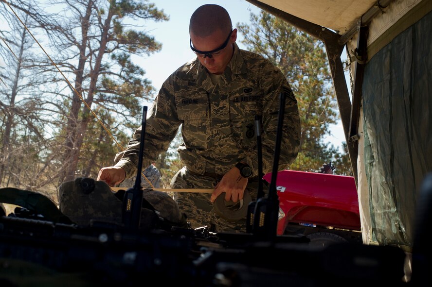 Staff Sgt. Ryan Fontaine, 91st Security Forces Group Global Strike Challenge team coach, prepares his gear during the tactics event of the 2014 GSC on Camp Guernsey, Wyo., Sept. 24, 2014. The security forces portion of the challenge was split into three different events; tactics, weapons firing, and the mental and physical challenge.  (U.S. Air Force photo/Senior Airman Brittany Y. Bateman)