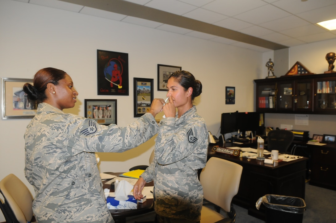 Staff Sgt. Jarimaris Garcia, command chief  executive assistant for the 79th Medical Wing received her flu mist on Sept. 25, 2014 by Staff Sgt. Sierra Johnson from 779th Medical Group Immunization Services Clinic.  The flu vaccine is mandatory for all military members and must be administered no later than Dec. 15.  (Air Force Photo)
