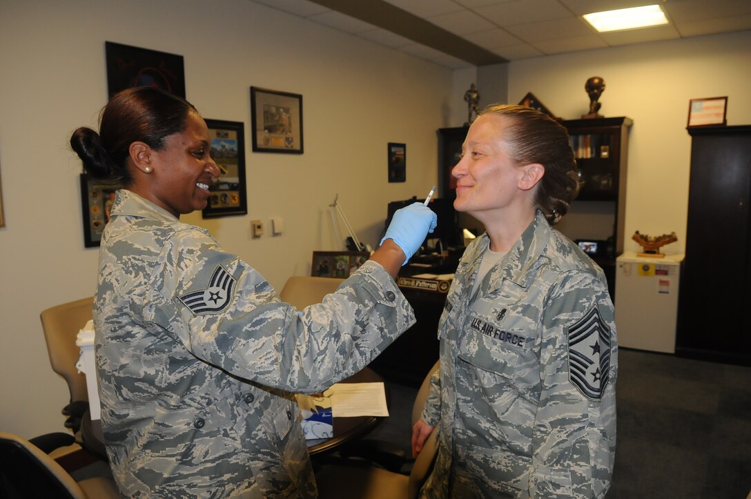 Chief Master Sgt. Michelle R. Thorsteinson-Richards, command chief  for the 79th Medical Wing received her flu mist on Sept. 25, 2014 by Staff Sgt. Sierra Johnson from 779th Medical Group Immunization Services Clinic.  The flu vaccine is mandatory for all military members and must be administered no later than Dec. 15.  (Air Force Photo by Staff Sgt. Jarimaris Garcia)