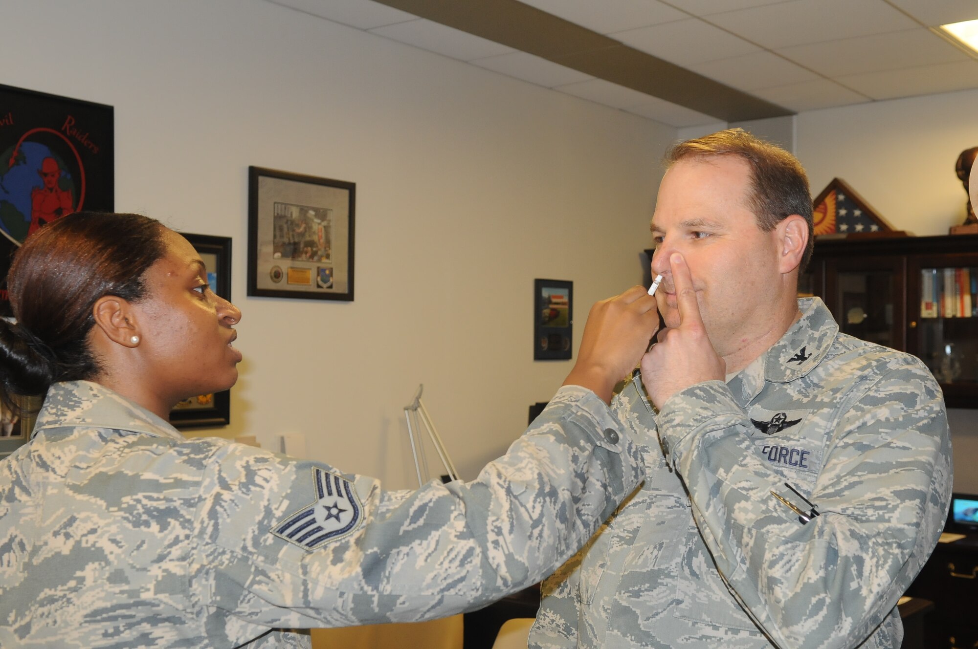 Col. Chris B. Patterson, vice commander for the Air Force District of Washington received his flu mist on Sept. 25, 2014 by Staff Sgt. Sierra Johnson from 779th Medical Group Immunization Services Clinic.  The flu vaccine is mandatory for all military members and must be administered no later than Dec. 15.  (Air Force Photo by Staff Sgt. Jarimaris Garcia)