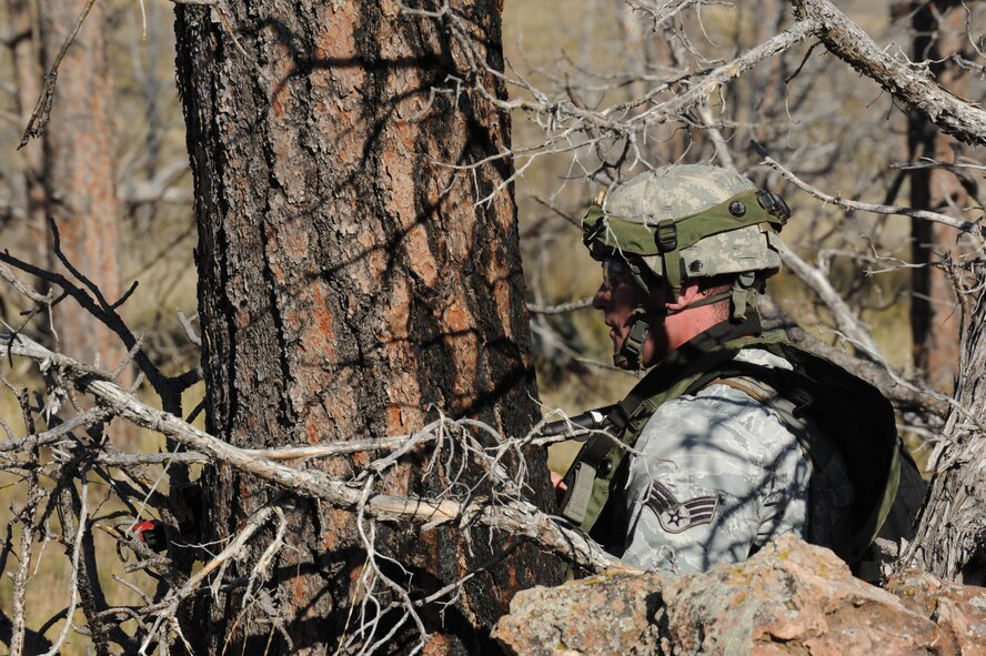 Senior Airman Brandon Lepkowski, 5th Security Forces Squadron Global Strike Challenge team member, surveys a simulated helicopter crash site during the tactics portion of the competition at Camp Guernsey, Wyo., Sept. 24, 2014. During tactics, the team traversed rugged terrain to reach a downed helicopter and liberate it from enemy forces. (U.S. Air Force photo/Senior Airman Stephanie Morris)