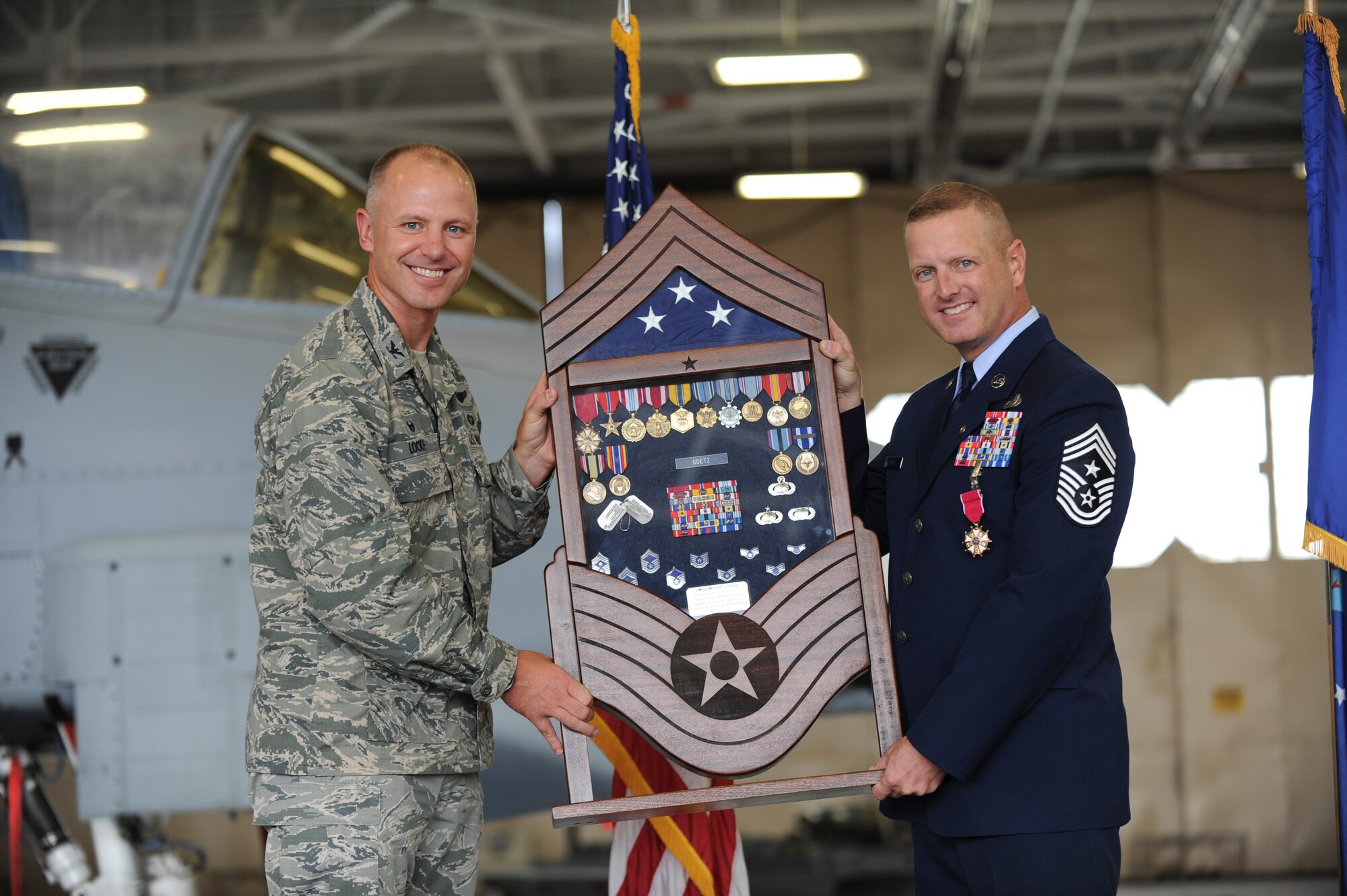 U.S. Air Force Col. Joseph Locke, 93d Air Ground Operations Wing commander, hands Chief Master Sgt. Michael Goetz, 93d Air Ground Operations Wing command chief, a shadow box during his retirement ceremony Sept. 26, 2014, at Moody Air Force Base, Ga. Shadow boxes are presented to members of the military upon retirement and contain various medals and awards the retiree earned throughout their military career. (U.S. Air Force photo by Andrea Jenkins/Released)