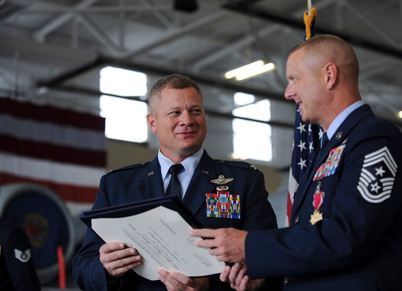 U.S. Air Force Col. Sam Milam, Air Education and Training Command inspector general, hands Chief Master Sgt. Michael Goetz, 93d Air Ground Operations Wing command chief, the official retirement certificate during his retirement ceremony Sept. 26, 2014, at Moody Air Force Base, Ga. As the command chief, Goetz advised the commander on matters influencing the readiness, training, morale, welfare, quality of life, and professional development of more than 2,800 Airmen at 20 locations. (U.S. Air Force photo by Andrea Jenkins/Released) 
