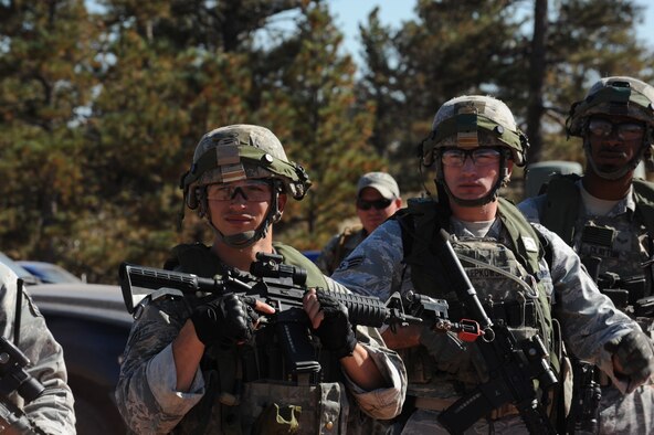 Members of the 5th Security Forces Squadron Global Strike Challenge team listen to instructions before the tactics portion of the competition at Camp Guernsey, Wyo., Sept. 24, 2014. During tactics, the team navigated their way through tall ridges, billowing smoke and sharp briers to a downed helicopter surrounded by enemy guards. (U.S. Air Force photo/Senior Airman Stephanie Morris)